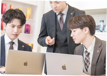 男性3名がノートパソコンを見ながら打ち合わせをしている